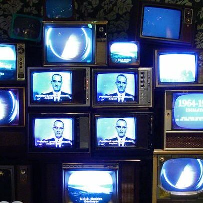 stacked vintage televisions with blue screens